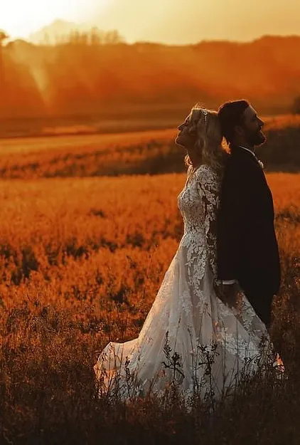 Bride and groom back to back under a golden sunset at a Wisconsin country wedding