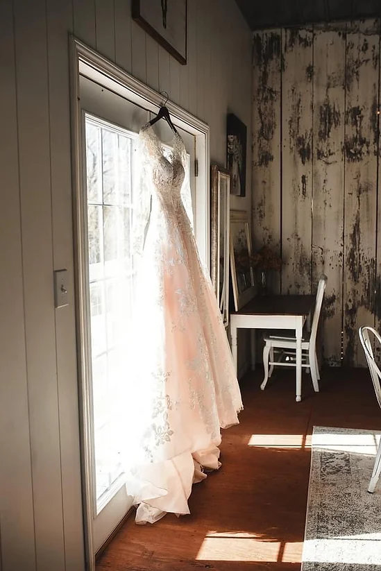 Bride's gown hanging beautifully in the sun in the bridal dressing room at Huser Farm